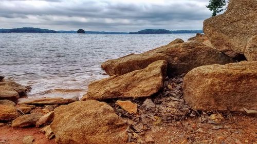 Close-up of rocks by sea against sky