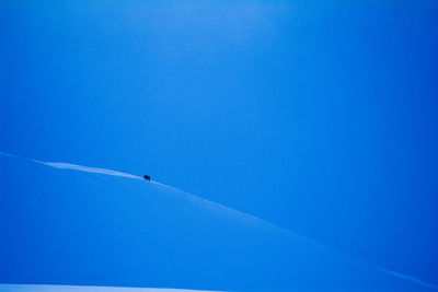 Low angle view of airplane flying against blue sky