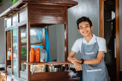 Portrait of smiling young woman standing at home