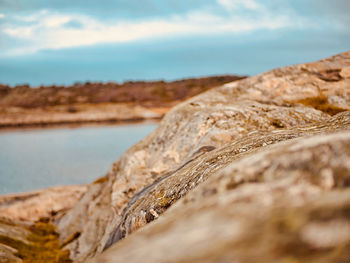 Close-up of rocks on shore against sky