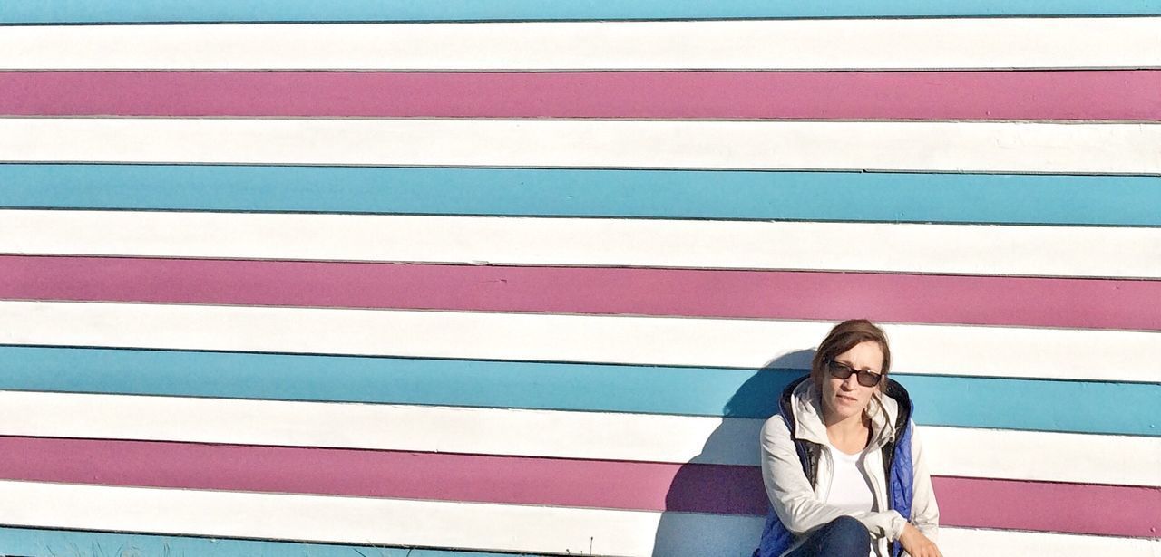 LOW SECTION OF WOMAN STANDING AGAINST WALL