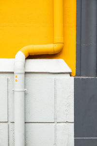 Close-up of yellow pipe against wall