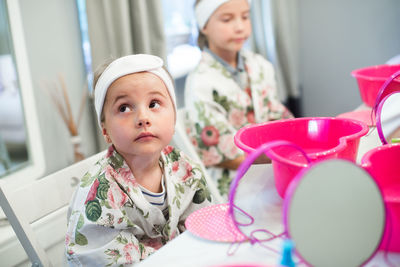 Girl looking up while sitting by friend in spa