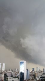 Buildings in city against cloudy sky