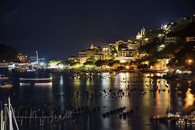 Illuminated cityscape against sky at night