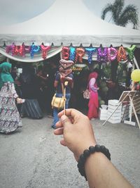 Midsection of people holding multi colored umbrellas