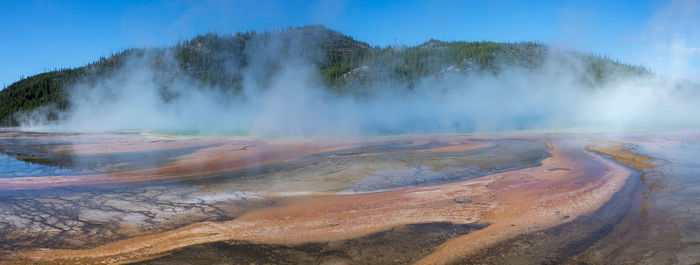 Scenic view of hot spring against sky