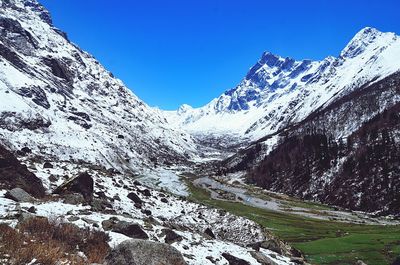 Scenic view of snowcapped mountains against clear blue sky