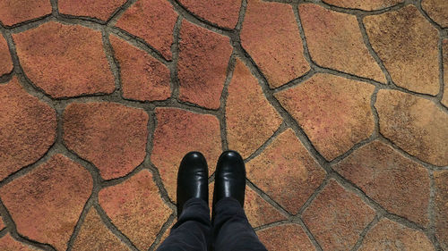 Low section of person standing on footpath