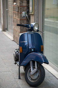 Motorcycle parked on street by footpath in city