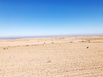 Scenic view of desert against clear blue sky