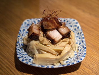 Close-up of char siu served in plate on wooden table