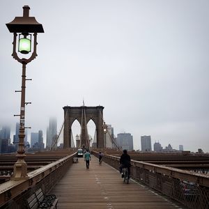 People on brooklyn bridge in city