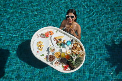High angle view of woman wearing sunglasses at swimming pool