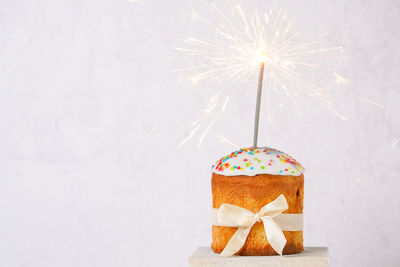 Delicious easter cake with sparkler on white background