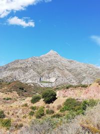 Scenic view of mountains against blue sky