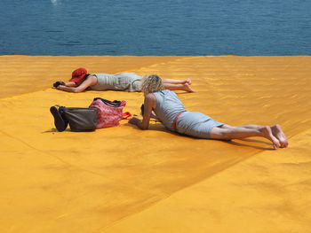 High angle view of men relaxing on shore