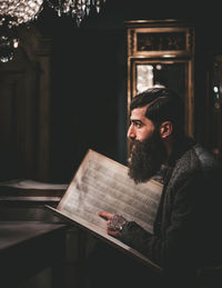 Portrait of young man sitting on book