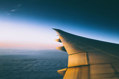 Close-up of airplane wing over sea against sky