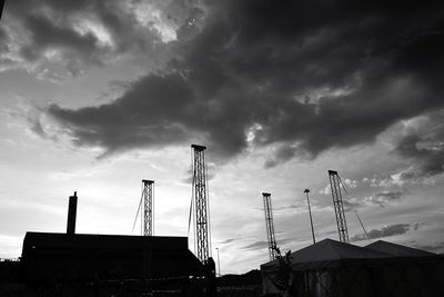 Low angle view of silhouette cranes against sky