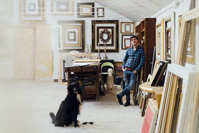 Mature man standing with dog in workshop