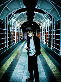 Full length portrait of man standing on railway station