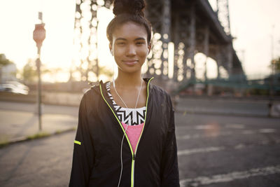 Portrait of young woman standing in city