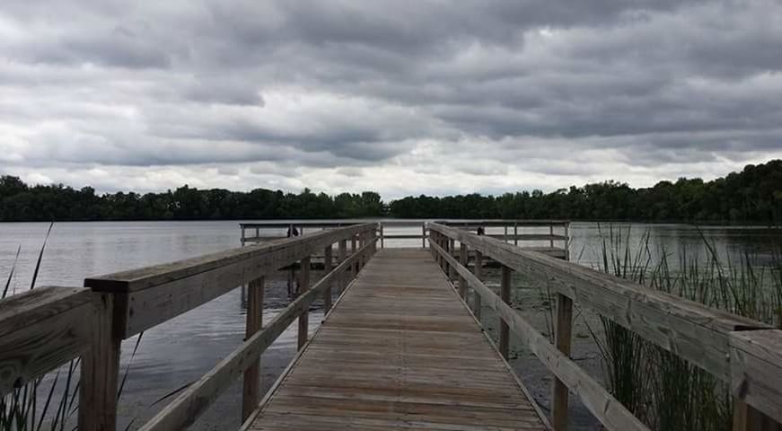 WOODEN PIER ON LAKE AGAINST CLOUDY SKY