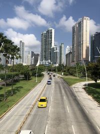 View of city street and buildings against sky