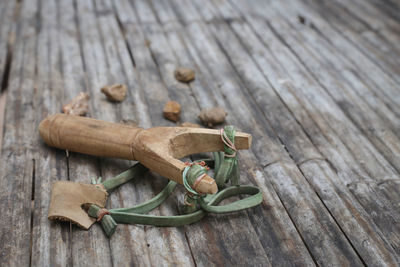 Close-up of slingshot and stones on wooden table