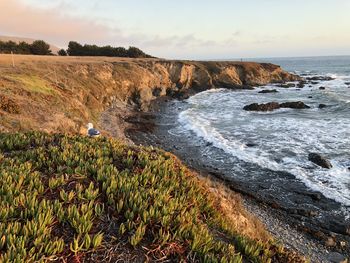 Scenic view of rocks on beach against sky