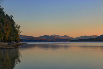 Scenic view of lake against clear sky during sunset