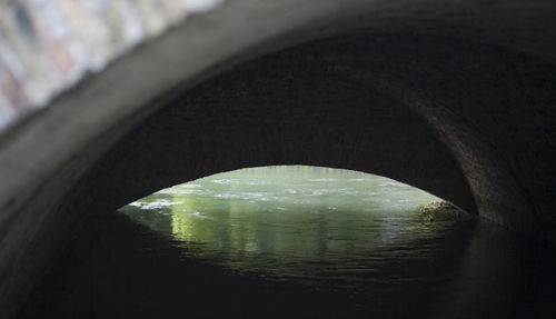 Arch bridge over river in tunnel