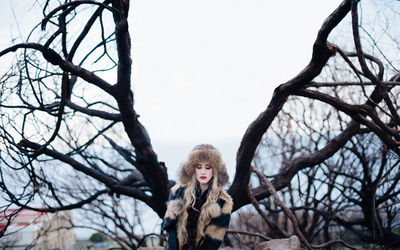 Low angle view of woman standing on tree