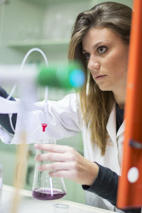 Portrait of young woman looking through glass window