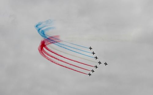 Low angle view of airshow against sky