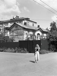 Portrait of woman standing against building