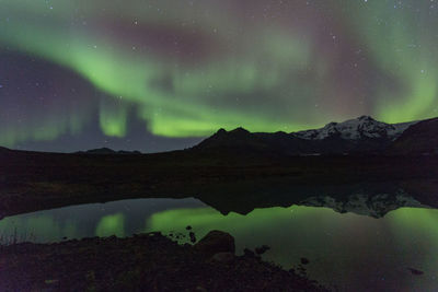 Scenic view of lake against mountain at night