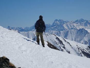 Rear view of man on snowcapped mountain