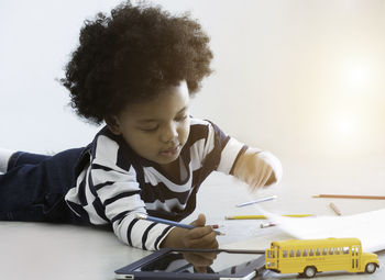 Preschool boy play toys on white background.