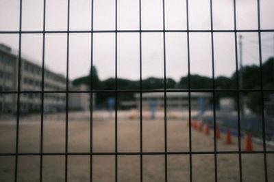 People seen through chainlink fence