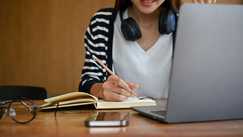 Midsection of businesswoman working on table