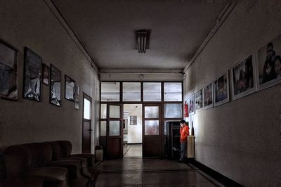 Rear view of man walking in corridor of building