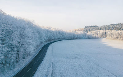 Road by snowcapped mountains against sky