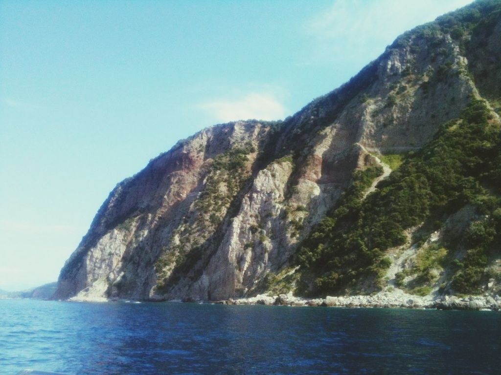 water, sea, mountain, scenics, rock formation, tranquil scene, beauty in nature, waterfront, tranquility, sky, rock - object, cliff, nature, blue, rocky mountains, rock, idyllic, non-urban scene, mountain range, day