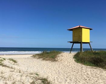 Lifeguard hut on beach against clear sky