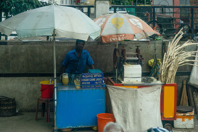 Rear view of man standing on wet street in rainy season