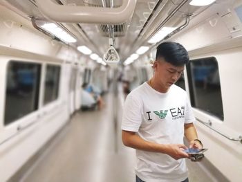 Man using mobile phone while standing in train