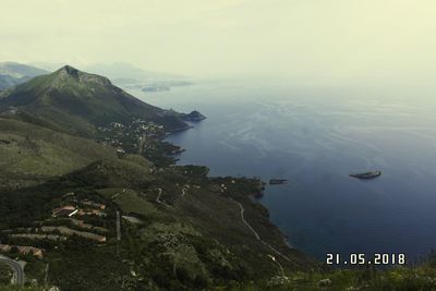 High angle view of sea and mountains against sky