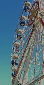 Low angle view of ferris wheel against blue sky